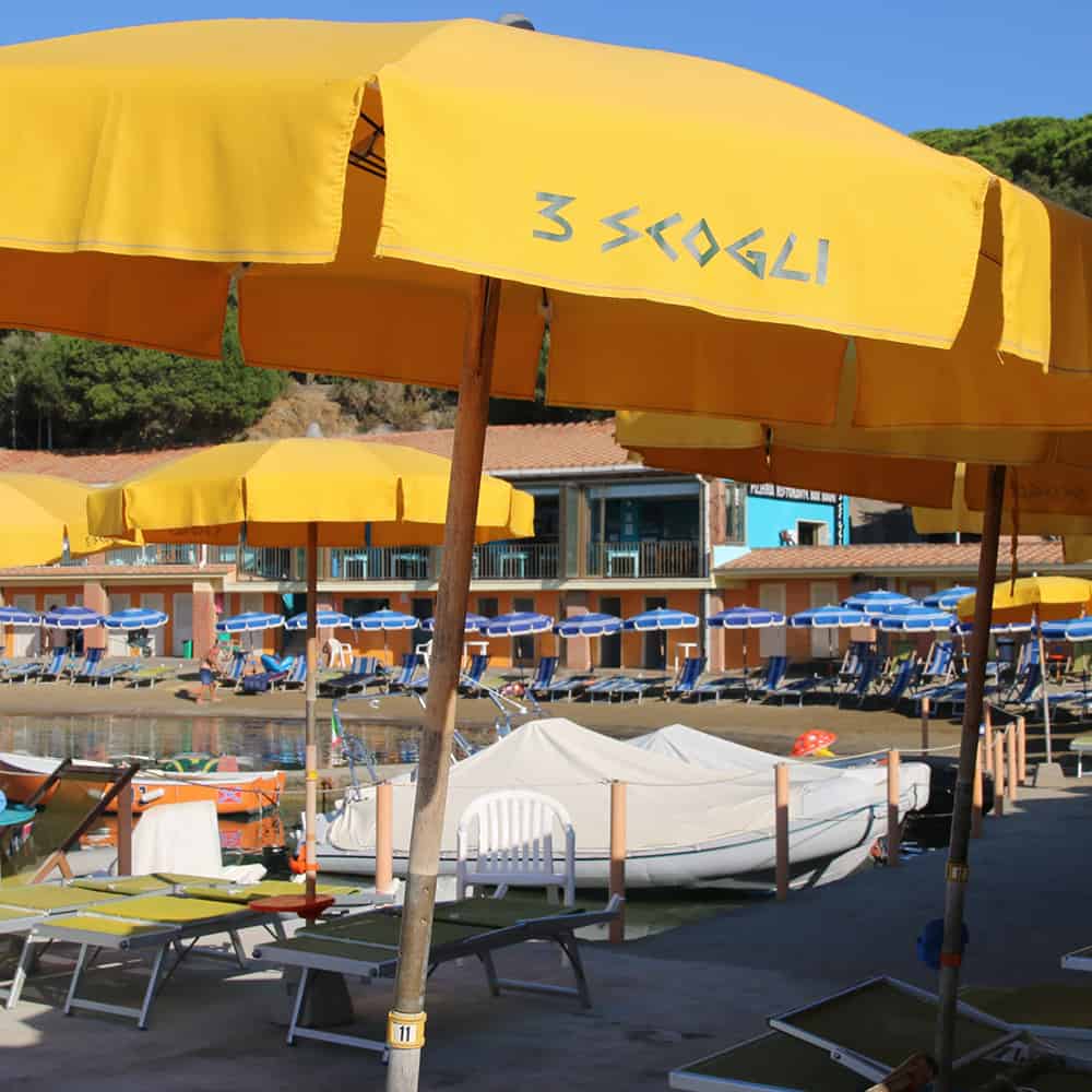 Ombrellone giallo con scritta “3 Scogli” al lido
